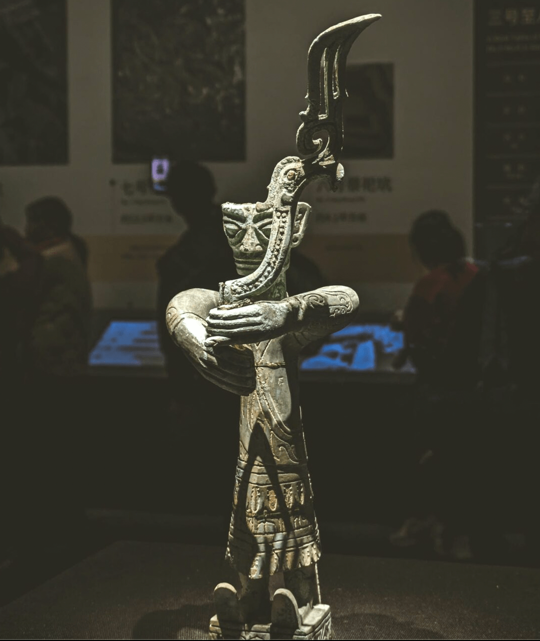 Bronze standing figure holding a bird
